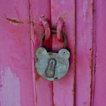 Old,rusted hook lock on closed weathered door