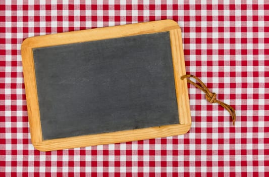 Empty slate on a red checkered tablecloth