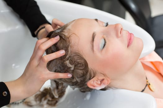 hairdresser washing customers hair in salon