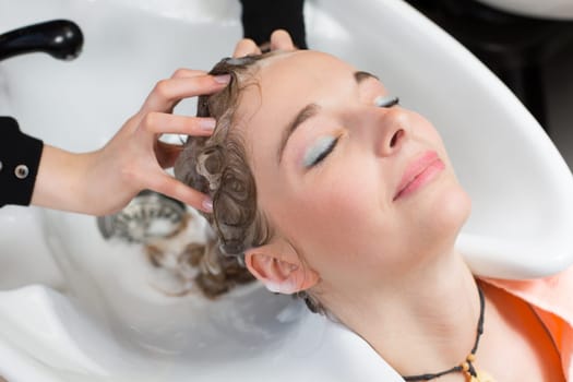 hairdresser washing customers hair in salon