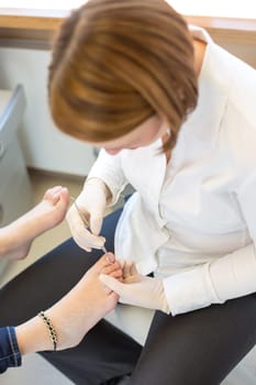Pedicure at work in salon caring for customers foot nails