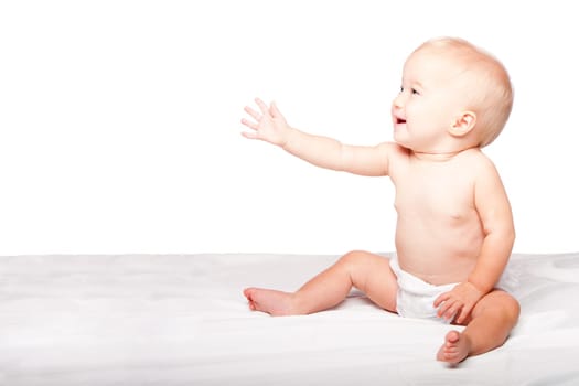 Cute adorable infant baby reaching out with hand asking for something while sitting, on white.