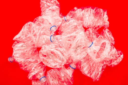 Squeezed bottles of mineral water with a red background.