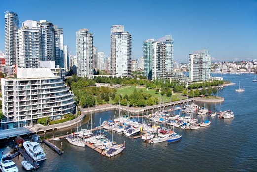 Looking down from the Granville Bridge, this is an east view of False Creek, a short inlet in the heart of Vancouver, British Columbia, Canada. The green area is George Wainborn park surrounded by tall condo buildings, the seaside bicycle route and the marina. False Creek separates downtown for the rest of the city.