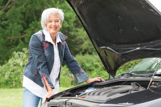 Senior citizen at a car with an open hood
