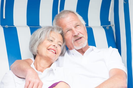 Portrait of a happy senior couple in a beach chair