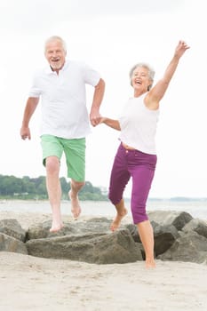 Active senior couple on the beach doing sports