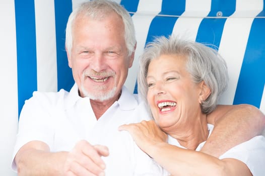 Portrait of a happy senior couple in a beach chair