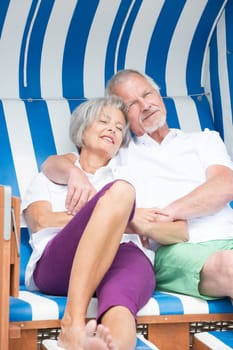 Portrait of a happy senior couple in a beach chair