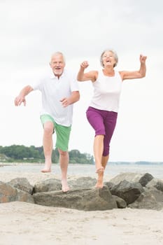 Active senior couple on the beach doing sports