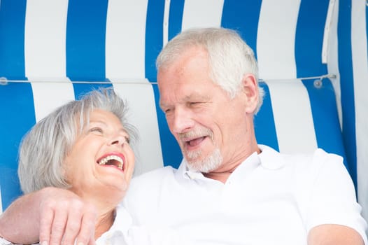 Portrait of a happy senior couple in a beach chair