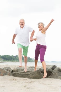 Active senior couple on the beach doing sports