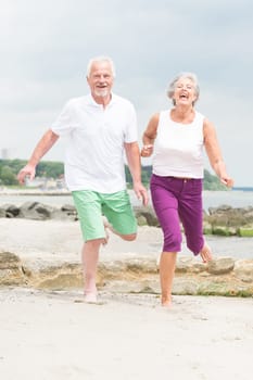 Active senior couple on the beach doing sports