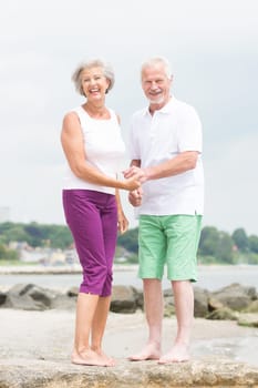 Active senior couple on the beach doing sports
