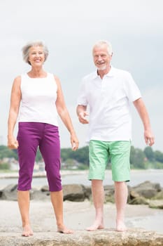Active senior couple on the beach doing sports