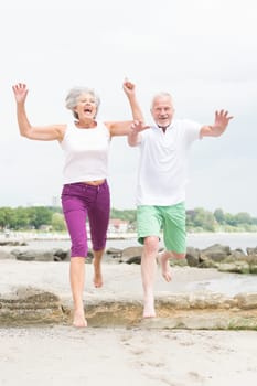 Active senior couple on the beach doing sports