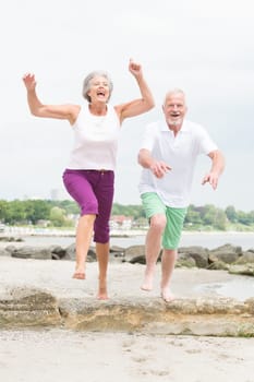 Active senior couple on the beach doing sports
