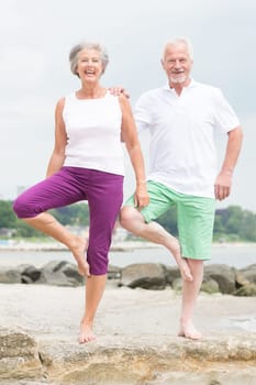 Active senior couple on the beach doing sports