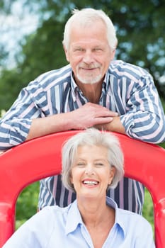 Happy senior couple on the beach on a children's slide