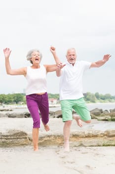 Active senior couple on the beach doing sports