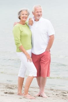Happy senior couple standing on the beach