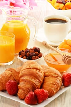 Breakfast with croissants, cup of coffee and fruits