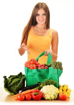 Young woman with variety of grocery products in shopping bag isolated on white