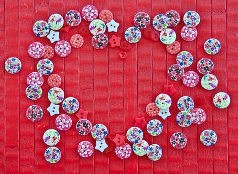 Red background with a frame of colorful heart-shaped knobs