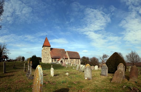 Church in graveyard. English village church Saint Lawrence in Guestling. Traditional medieval place of Christian worship in England