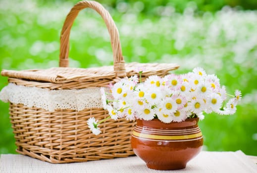 A bouquet of daisies in a pot on the table for a picnic