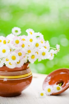 Bouquet of wild flowers in a pot at the table