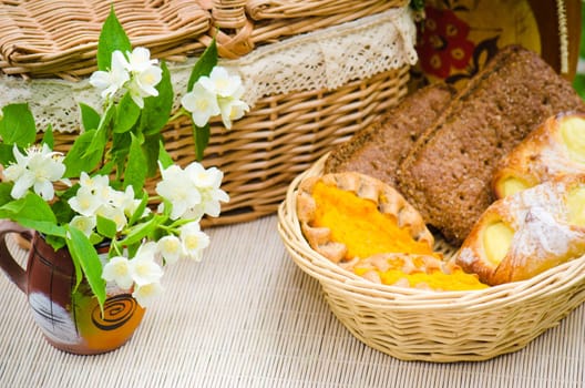 Buns in a wicker basket and a bouquet of jasmine flowers