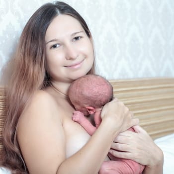 Mother holding a newborn baby skin-to-skin contact