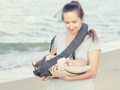 Young mother with baby on the beach