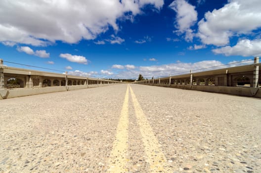 Low angle view of old abandoned highway with a beautiful blue sky