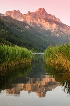 Mountain in the sunset with reflection in the water of a lake