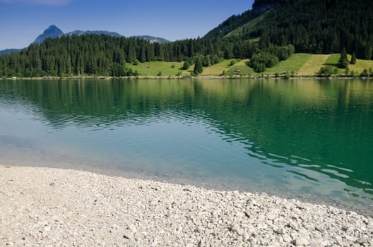 Stones on the lake in Tyrol with turquoise water
