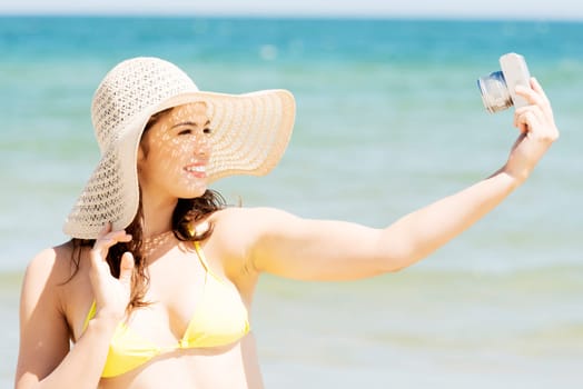 attractive cheerful summer woman talking pictures with digital camera.