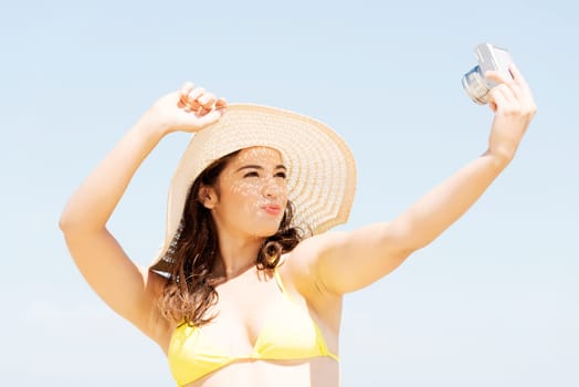 attractive cheerful summer woman talking pictures with digital camera.