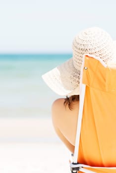 woman sunbathing and relaxing on beach chair.