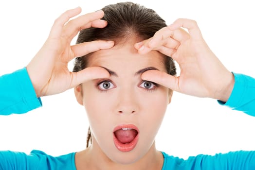 young shocked woman checking her first wrinkles on forehead