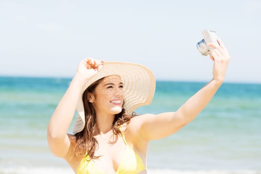 Attractive cheerful summer woman talking pictures with digital camera.