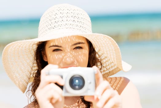 attractive cheerful summer woman talking pictures with digital camera.