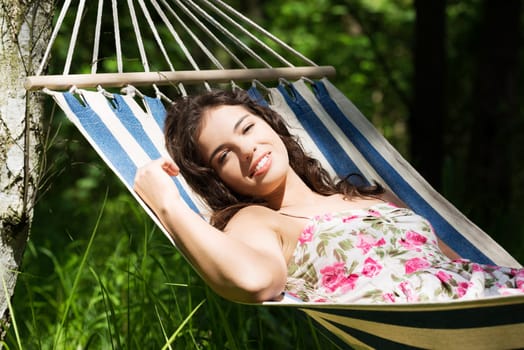 young woman lying in a hammock in the garden