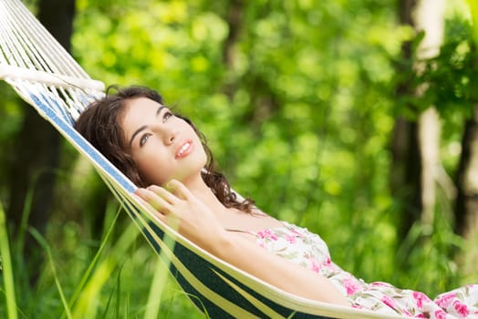 Young woman lying in a hammock in garden