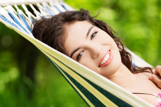 young woman lying in a hammock in the garden