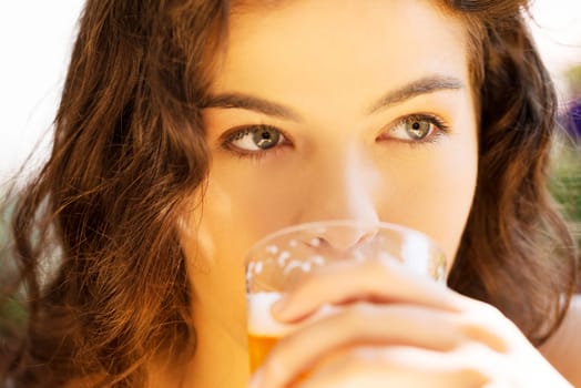attractive young woman drinking beer on a sidewalk cafe.