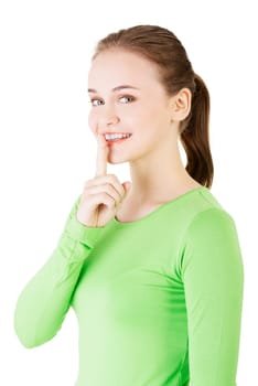Hush be quiet woman isolated. Teen girl with finger on her lips.
