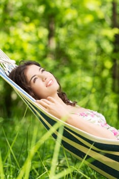 Young woman lying in a hammock in garden