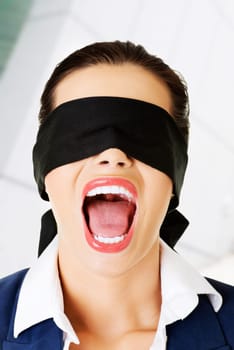 Portrait of a frighten beautiful young blindfold woman screaming